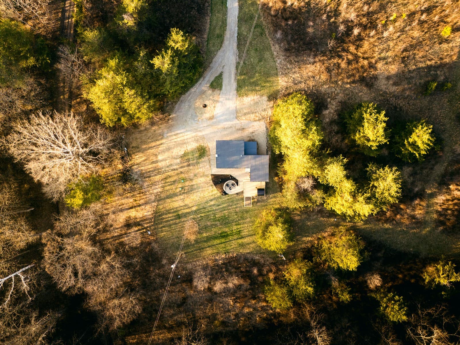 A drone view looking down on a cabin tucked into the trees